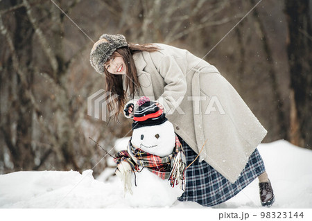 雪だるまを作り楽しそうにしている女性 98323144