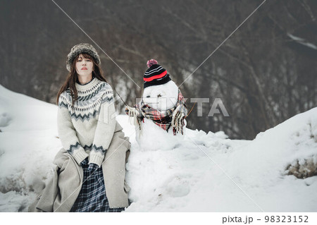 雪だるまを作り楽しそうにしている女性 98323152
