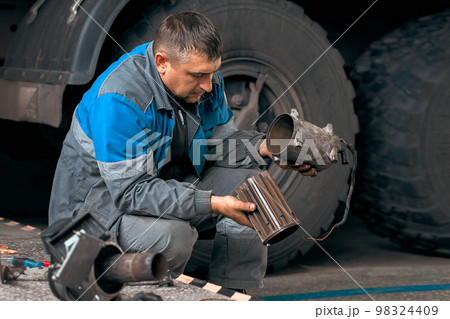 Auto mechanic repairs truck. Professional repair and diagnostics of cargo tractors and equipment 98324409