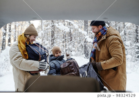 Family together with their child arranging picnic in the forest during winter vacations Family together with their child arranging picnic in the forest during winter vacations 98324529