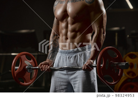 Cropped image of muscular body of sportive man training shirtless in gym indoors. Lifting barbell exercise. Relief body shape. Concept of sport, workout, strength 98324953