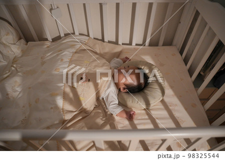 赤ちゃんが夜に寝かしつけられて寝ている姿 98325544