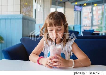 A girl in a cafe, drinking a milkshake. Healthy food 98325700