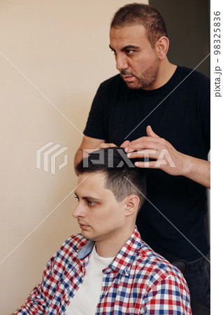 Barber and satisfied bearded man in front of the mirror 98325836