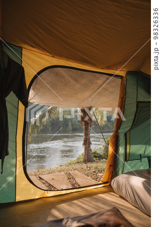 Inside of large comfortable camping tent on campground in the tropical forest by riverside on vacation 98326336