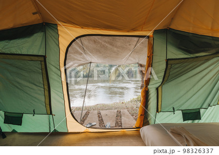 Inside of large comfortable camping tent on campground in the tropical forest by riverside on vacation 98326337
