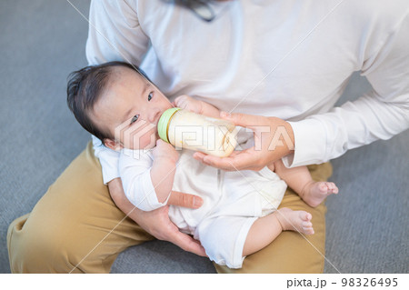 パパに抱っこされてミルクを飲む生後3か月の赤ちゃん パパに抱っこされてミルクを飲む生後3か月の赤ちゃん 98326495