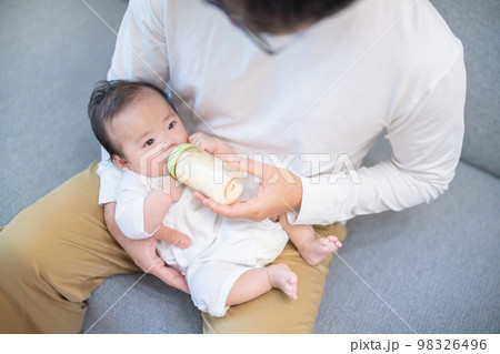 パパに抱っこされてミルクを飲む生後3か月の赤ちゃん	 98326496