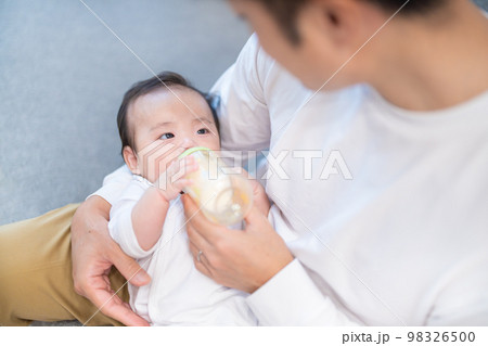 パパに抱っこされてミルクを飲む生後3か月の赤ちゃん パパに抱っこされてミルクを飲む生後3か月の赤ちゃん 98326500