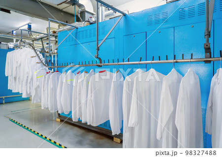 Washed clothes are being conveyed to ironing machine 98327488