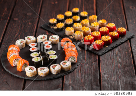 Rolls set with fish shrimp and caviar sushi close-up - asian food and japanese cuisine concept Rolls set with fish shrimp and caviar sushi close-up - asian food and japanese cuisine concept 98330993