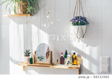 Hanging crystal sun catcher against white tile wall Hanging crystal sun catcher against white tile wall 98332060