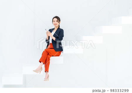 階段に座ってスマホを見る若いビジネスウーマン 階段に座ってスマホを見る若いビジネスウーマン 98333299