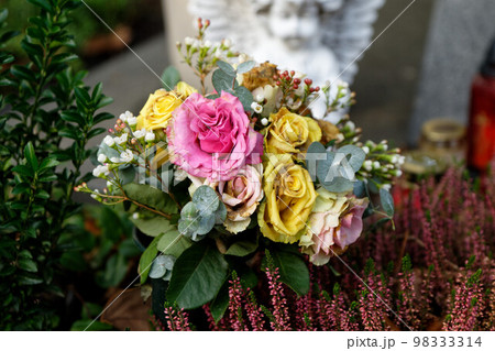 faded pastel roses on a grave faded pastel roses on a grave 98333314