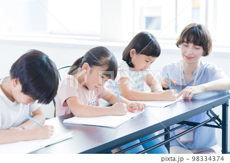教育　英会話教室で勉強する子供とネイティブ講師 98334374