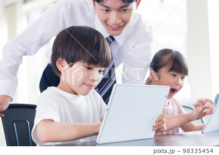 タブレットで学習する子供たちと先生 98335454