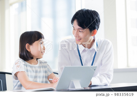 タブレットで学習する女の子と講師 98335619