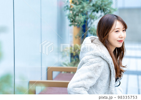 休日の外出でベンチに座る若い女性 98335753