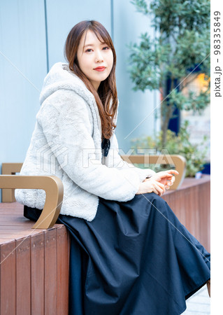休日の外出でベンチに座る若い女性 休日の外出でベンチに座る若い女性 98335849