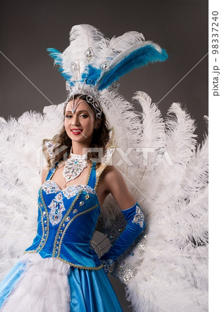 Smiling woman in vintage blue dress with feathers Smiling woman in vintage blue dress with feathers 98337240