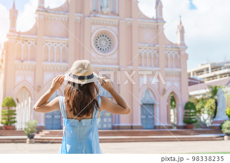 Woman Traveler with blue dress visiting in Da Nang city. Tourist sightseeing the Da Nang Cathedral church. Landmark and popular for tourist attraction. Vietnam and Southeast Asia travel concept Woman Traveler with blue dress visiting in Da Nang city. Tourist sightseeing the Da Nang Cathedral church. Landmark and popular for tourist attraction. Vietnam and Southeast Asia travel concept 98338235