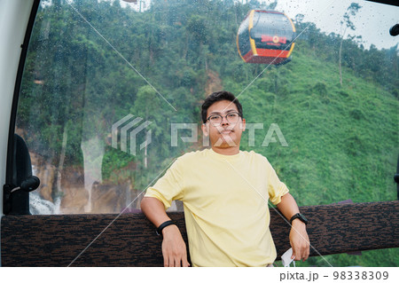 man sitting in Cable car with Ba Na Hills Mountain in the fog. Landmark and popular. Da Nang, Vietnam and Southeast Asia travel concept man sitting in Cable car with Ba Na Hills Mountain in the fog. Landmark and popular. Da Nang, Vietnam and Southeast Asia travel concept 98338309