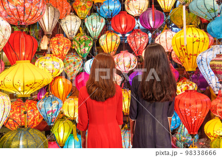 Couple women wearing Ao Dai Vietnamese dress with colorful lantern, traveler sightseeing at Hoi An ancient town in central Vietnam.landmark for tourist attractions.Vietnam and Southeast travel concept 98338666