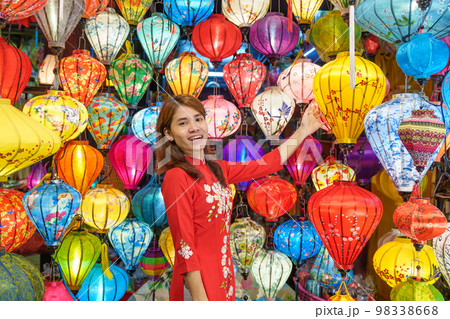 happy woman wearing Ao Dai Vietnamese dress with colorful lanterns, traveler sightseeing at Hoi An ancient town in central Vietnam.landmark for tourist attractions.Vietnam and Southeast travel concept 98338668