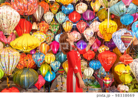 happy woman wearing Ao Dai Vietnamese dress with colorful lanterns, traveler sightseeing at Hoi An ancient town in central Vietnam.landmark for tourist attractions.Vietnam and Southeast travel concept 98338669