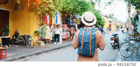 happy Solo traveler sightseeing at Hoi An ancient town in central Vietnam, man traveling with backpack and hat. landmark and popular for tourist attractions. Vietnam and Southeast Asia travel concept 98338792