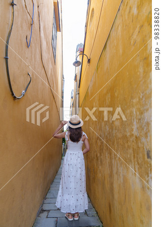 happy traveler sightseeing at Hoi An ancient town in central Vietnam, woman with dress and hat traveling. landmark and popular for tourist attractions. Vietnam and Southeast Asia travel concept 98338820