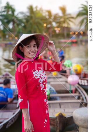 happy woman wearing Ao Dai Vietnamese dress, traveler visit Thu Bon River and Sightseeing Boat Ride at Hoi An ancient town. landmark for tourist attractions.Vietnam and Southeast travel concept 98338854