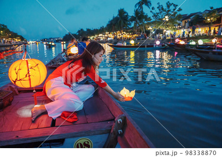 woman wearing Ao Dai Vietnamese dress, traveler Sightseeing Boat Ride and floating paper lantern at Hoi An ancient town. landmark for tourist attractions.Vietnam and Southeast travel concept woman wearing Ao Dai Vietnamese dress, traveler Sightseeing Boat Ride and floating paper lantern at Hoi An ancient town. landmark for tourist attractions.Vietnam and Southeast travel concept 98338870