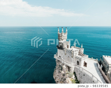 Crimea Swallow's Nest Castle on the rock over the Black Sea. It is a tourist attraction of Crimea. Amazing aerial view of the Crimea coast with the castle above abyss on sunny day. 98339585