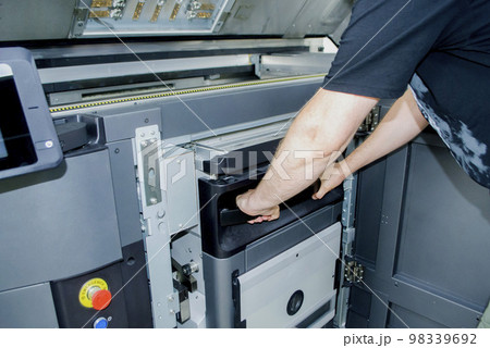 The worker moves the working camera of the 3D printer into the 3D printer. Large industrial 3D printer printing with polyamide powder in a production laboratory. Multi Jet Fusion. Industrial equipment The worker moves the working camera of the 3D printer into the 3D printer. Large industrial 3D printer printing with polyamide powder in a production laboratory. Multi Jet Fusion. Industrial equipment 98339692