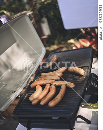 Fresh sausage and hot dogs grilling outdoors . Concept picnic Fresh sausage and hot dogs grilling outdoors . Concept picnic 98339951