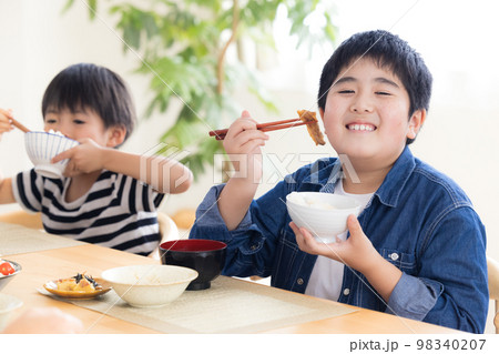 ファミリー　食事　お肉を食べる男の子 98340207