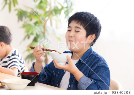 ファミリー　食事　お肉を食べる男の子 98340208