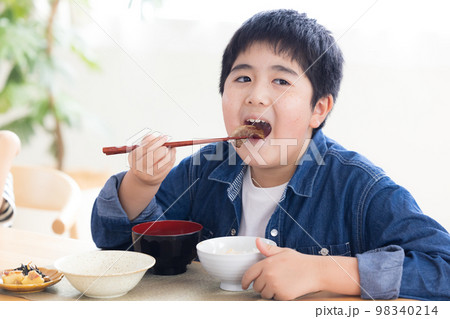 ファミリー　食事　お肉を食べる男の子 98340214