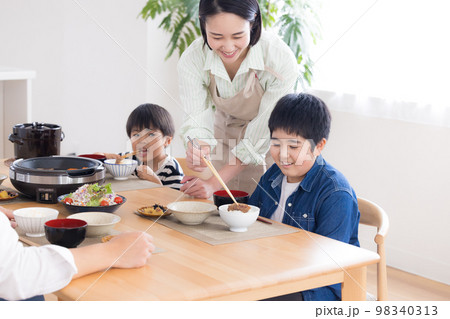 ファミリー　食事　お肉を食べる男の子 98340313
