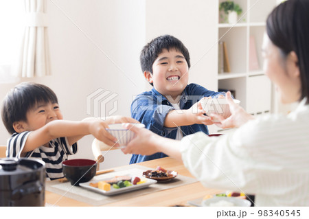 ファミリー 食事 ご飯をおかわりする兄弟 ファミリー 食事 ご飯をおかわりする兄弟 98340545
