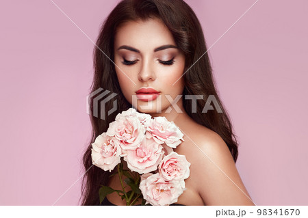Beautiful young woman with a rose flower Beautiful young woman with a rose flower 98341670