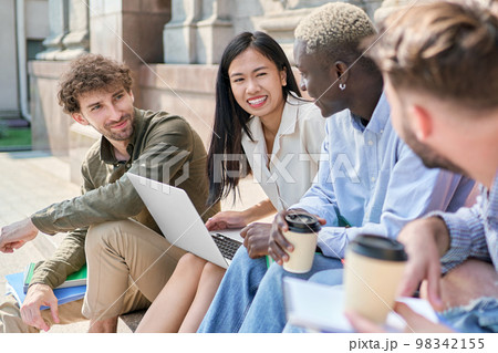 multicultural team of students is chatting on the steps of the campus. multicultural team of students is chatting on the steps of the campus. 98342155