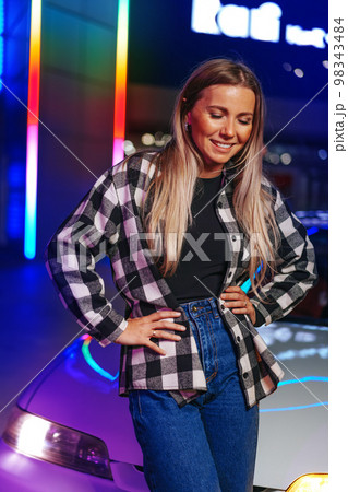 Young hipster girl near old sport car at night city Young hipster girl near old sport car at night city 98343484
