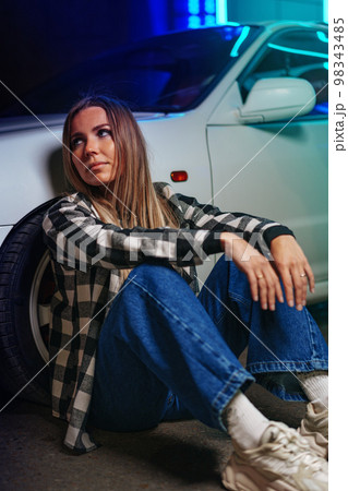 Young hipster girl near old sport car at night city Young hipster girl near old sport car at night city 98343485