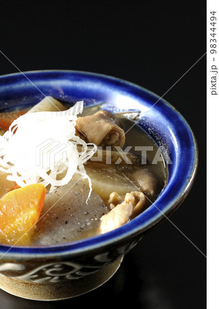 人参、蒟蒻、牛蒡、大根の入った豚のもつ煮込みを黒背景で撮影 98344494