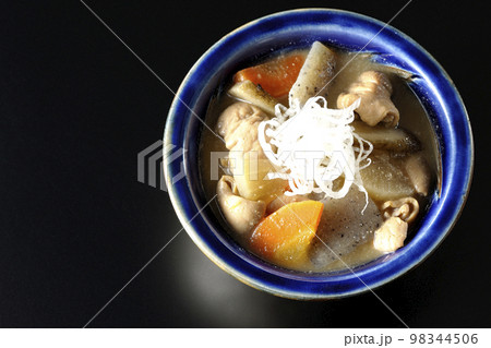 人参、蒟蒻、牛蒡、大根の入った豚のもつ煮込みを黒背景で俯瞰撮影 98344506