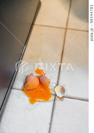 落として割れた生卵 98344783