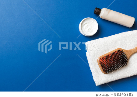 cosmetic for hair care, cream and towel on a colored background top view. flat lay 98345385