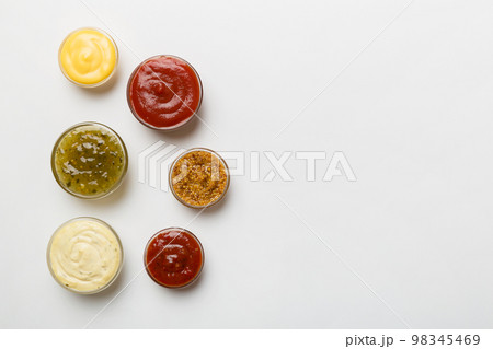 Different types of sauces in bowls on a colored Board . Top view. various sauces copy space 98345469